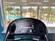 Treadmill with view of tropical beach, pool, and palms, offering a picturesque workout scene at 880 Mandalay Ave # N105, Clearwater Beach, FL 33767