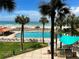 The pool is bordered by palm trees and lounge chairs offering a tropical escape by the ocean at 880 Mandalay Ave # N105, Clearwater Beach, FL 33767