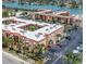 Aerial view of large condo complex surrounded by a parking lot, palms, and a beautiful body of water at 8901 Blind Pass Rd # 224, St Pete Beach, FL 33706