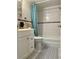 Bathroom with a white vanity, toilet, white-tiled tub and shower featuring a patterned accent tile and teal curtain at 8901 Blind Pass Rd # 224, St Pete Beach, FL 33706