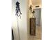 Hallway with light walls, decorative jellyfish, and a rustic-style cabinet with a plant, next to the white door at 8901 Blind Pass Rd # 224, St Pete Beach, FL 33706