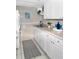Bright kitchen features white cabinetry, stainless steel sink, and modern appliances at 8901 Blind Pass Rd # 224, St Pete Beach, FL 33706