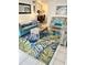 Comfortable living room featuring a teal sofa, tropical rug, and wicker loveseat at 8901 Blind Pass Rd # 224, St Pete Beach, FL 33706