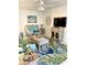 Cozy living room features a ceiling fan, wicker seating, and tropical-themed decor at 8901 Blind Pass Rd # 224, St Pete Beach, FL 33706