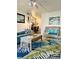 Comfortable living room featuring a teal sofa, tropical rug, and view to dining area at 8901 Blind Pass Rd # 224, St Pete Beach, FL 33706