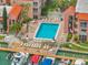 Aerial view of the community pool featuring lounge chairs, tables and access to the boat docks at 8901 Blind Pass Rd # 224, St Pete Beach, FL 33706