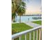 Beautiful waterfront view featuring palm trees, green grass, and condos in the distance at 8901 Blind Pass Rd # 224, St Pete Beach, FL 33706