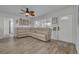 Comfortable living room featuring a plush sectional sofa, a ceiling fan and wood look flooring at 9325 90Th Ter, Seminole, FL 33777