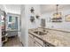 Modern kitchen with granite countertops, stainless steel sink, and decorative shelving for added charm at 10405 Villa View Cir # 10405, Tampa, FL 33647