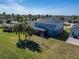 Aerial view of the home with a screened in lanai and a large backyard with palm trees at 11305 Emerald Shore Dr, Riverview, FL 33579