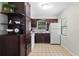 A compact kitchen featuring a large pantry, white appliances, and neutral tile flooring at 1155 27Th S Ave, St Petersburg, FL 33705