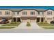 Townhome exterior view with a two-car garage, red shutters and beautifully landscaped front yards at 11903 Castine St, New Port Richey, FL 34654