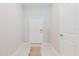 Clean and bright hallway featuring a white door and neutral-colored tile flooring at 11903 Castine St, New Port Richey, FL 34654