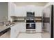 Bright kitchen with stainless steel appliances, white cabinets, and granite countertops at 11903 Castine St, New Port Richey, FL 34654