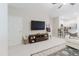 Bright living room features neutral walls, tile floors, TV, and flows into the modern kitchen at 11903 Castine St, New Port Richey, FL 34654