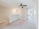 Spacious carpeted loft area with stairs, ceiling fan, and ample natural light at 11903 Castine St, New Port Richey, FL 34654