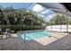 Backyard screen enclosed pool with brick patio, and a view of green foliage at 12296 Keyridge Loop, Largo, FL 33778