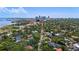 An aerial view pointing to the property, surrounded by lush trees and showcasing the city skyline at 1311 Beach Ne Dr, St Petersburg, FL 33701