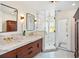 A bright bathroom with double vanity, modern fixtures, and a glass enclosed shower with mosaic tiling at 1311 Beach Ne Dr, St Petersburg, FL 33701