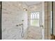 Luxurious marble shower featuring gold fixtures and elegant patterned window at 1311 Beach Ne Dr, St Petersburg, FL 33701