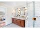 A bright bathroom with a double vanity, marble countertops, and a glass-enclosed shower at 1311 Beach Ne Dr, St Petersburg, FL 33701