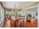 Well-lit dining room featuring a large wooden table, chandelier, brick accent wall and access to other rooms at 1311 Beach Ne Dr, St Petersburg, FL 33701