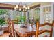 Bright dining room with a large wood table, chairs, chandelier and greenery at 1311 Beach Ne Dr, St Petersburg, FL 33701