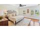 Bright main bedroom featuring hardwood floors, ceiling fan, large windows, and neutral decor at 1311 Beach Ne Dr, St Petersburg, FL 33701