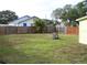 Fenced backyard with grass and mature trees providing shade at 1554 Tilley Ave, Clearwater, FL 33756