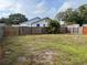 Large backyard with a wooden fence, grass, and a palm tree at 1554 Tilley Ave, Clearwater, FL 33756