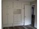 Bedroom features white, built-in storage cabinets and wood floors at 1554 Tilley Ave, Clearwater, FL 33756