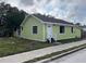 Charming home featuring a white front door, a bright green exterior and neat landscaping at 1554 Tilley Ave, Clearwater, FL 33756