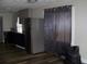 Kitchen featuring stainless steel refrigerator and appliances, complemented by black cabinets and wood-look flooring at 1554 Tilley Ave, Clearwater, FL 33756