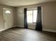 Inviting living room with wood-look floors, a bright white door, and natural light from the window at 1554 Tilley Ave, Clearwater, FL 33756
