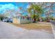 Charming single-story home with light yellow paint, lush trees, and a driveway at 1800 27Th N Ave, St Petersburg, FL 33713
