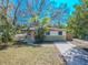 Charming single-story home with a pink door, a well-maintained lawn, and a freshly paved driveway at 1800 27Th N Ave, St Petersburg, FL 33713