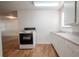 Bright kitchen featuring wood floors, white appliances, and white cabinets at 1800 27Th N Ave, St Petersburg, FL 33713