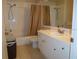 Well-lit bathroom with a white vanity, toilet, and shower-tub combination behind a curtain at 18106 Peregrines Perch Pl # 5208, Lutz, FL 33558