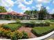 A grand entrance with a water fountain, colorful flowers, and a red tiled roof at 18106 Peregrines Perch Pl # 5208, Lutz, FL 33558