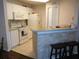 Bright kitchen with white cabinets and appliances, featuring a breakfast bar with seating and tiled floor at 18106 Peregrines Perch Pl # 5208, Lutz, FL 33558