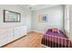 Bright bedroom with hardwood floors features dresser, white frame bed, and natural light streaming through the window at 223 33Rd N Ave, St Petersburg, FL 33704