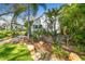 The front yard features a stone pathway winding through garden beds and mature palms at 223 33Rd N Ave, St Petersburg, FL 33704