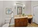 Well-lit bathroom with sconces, decorative mirror, and wood vanity with granite countertop at 3512 Kalebs Forest Trl, Dover, FL 33527