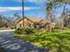 View of the exterior, showing the driveway, and the house surrounded by mature trees at 3512 Kalebs Forest Trl, Dover, FL 33527