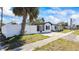 Exterior view of home featuring a white privacy fence and mature palm trees at 3601 21St N St, St Petersburg, FL 33713