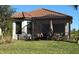 View of the screened-in patio and the house with red tile roof from the well-maintained lawn at 4363 Cairoli Ct, Wesley Chapel, FL 33543