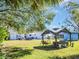 Expansive backyard with lush lawn, mature trees, gazebo, and outdoor seating area at 510 N Missouri Ave, Clearwater, FL 33755