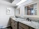 Bathroom featuring double sink with granite countertop and matching framed mirrors at 5253 Sandra Dr, Weeki Wachee, FL 34607
