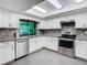 Bright kitchen features stainless appliances, stone backsplash, granite counters, and modern white cabinets at 5253 Sandra Dr, Weeki Wachee, FL 34607
