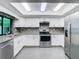 This bright and open kitchen features stainless appliances, granite counters and white cabinets at 5253 Sandra Dr, Weeki Wachee, FL 34607